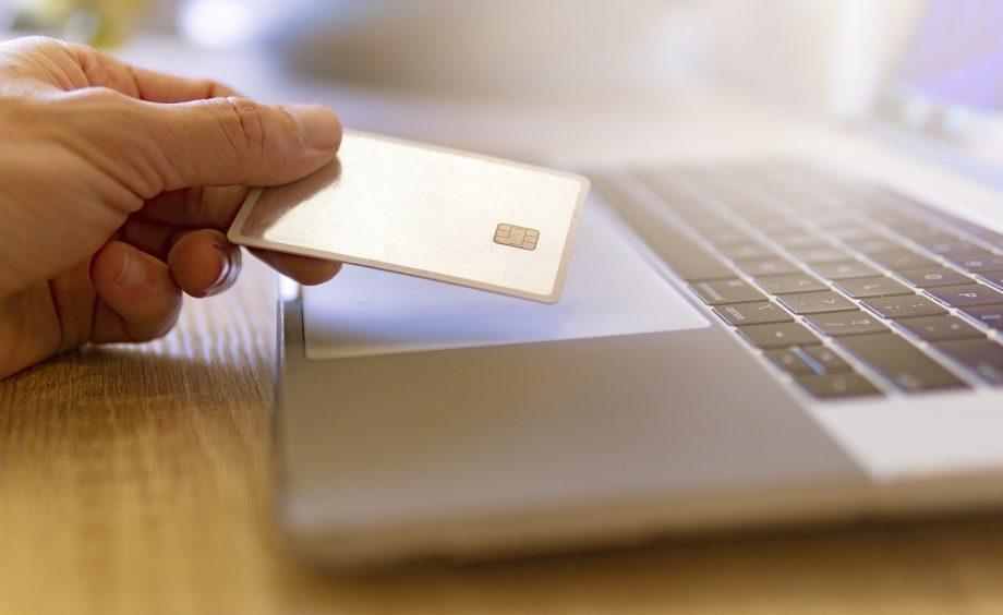 Webshophouder controleert betalingsgegevens op laptop om fraude te herkennen