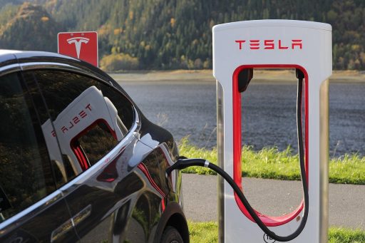 Elektrische auto die oplaadt via een wallbox op de oprit van een woonhuis