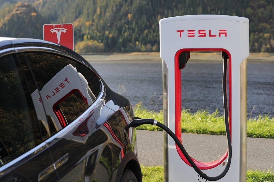 Elektrische auto die oplaadt via een wallbox op de oprit van een woonhuis