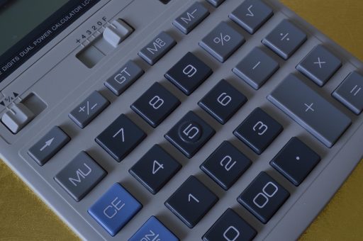 Persoon die thuis zijn maandbudget berekent voordat hij gaat investeren in Bitcoin