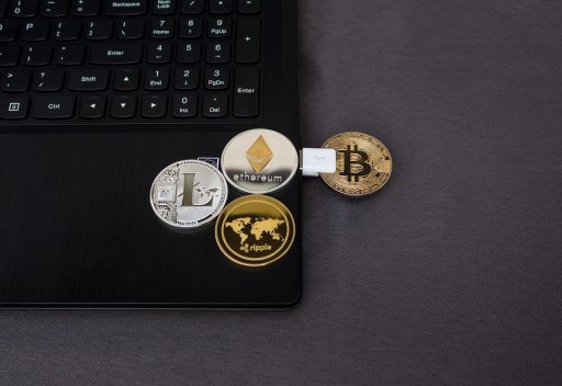 Digitale cryptomunten naast een laptop op een bureau