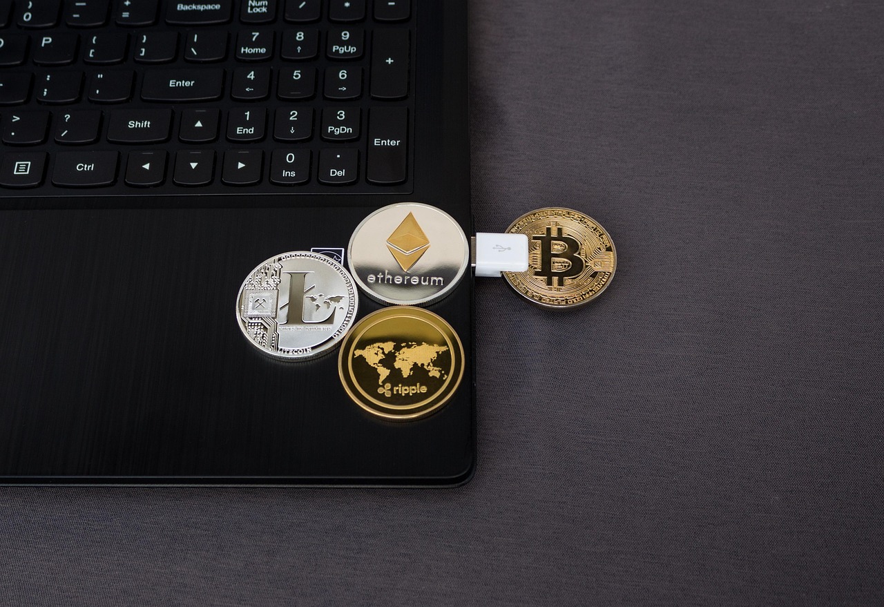 Digitale cryptomunten naast een laptop op een bureau