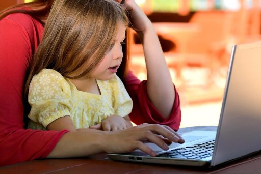 Ouder en kind kijken samen op een laptop naar het Somtoday ouderdashboard