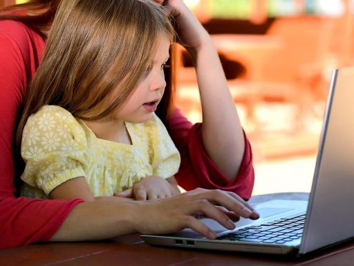Ouder en kind kijken samen op een laptop naar het Somtoday ouderdashboard