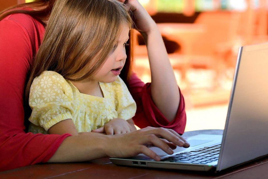 Ouder en kind kijken samen op een laptop naar het Somtoday ouderdashboard